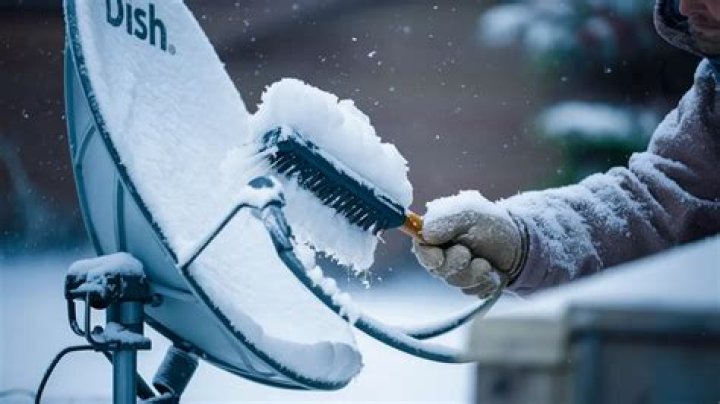 How do I clear snow from my satellite dish?